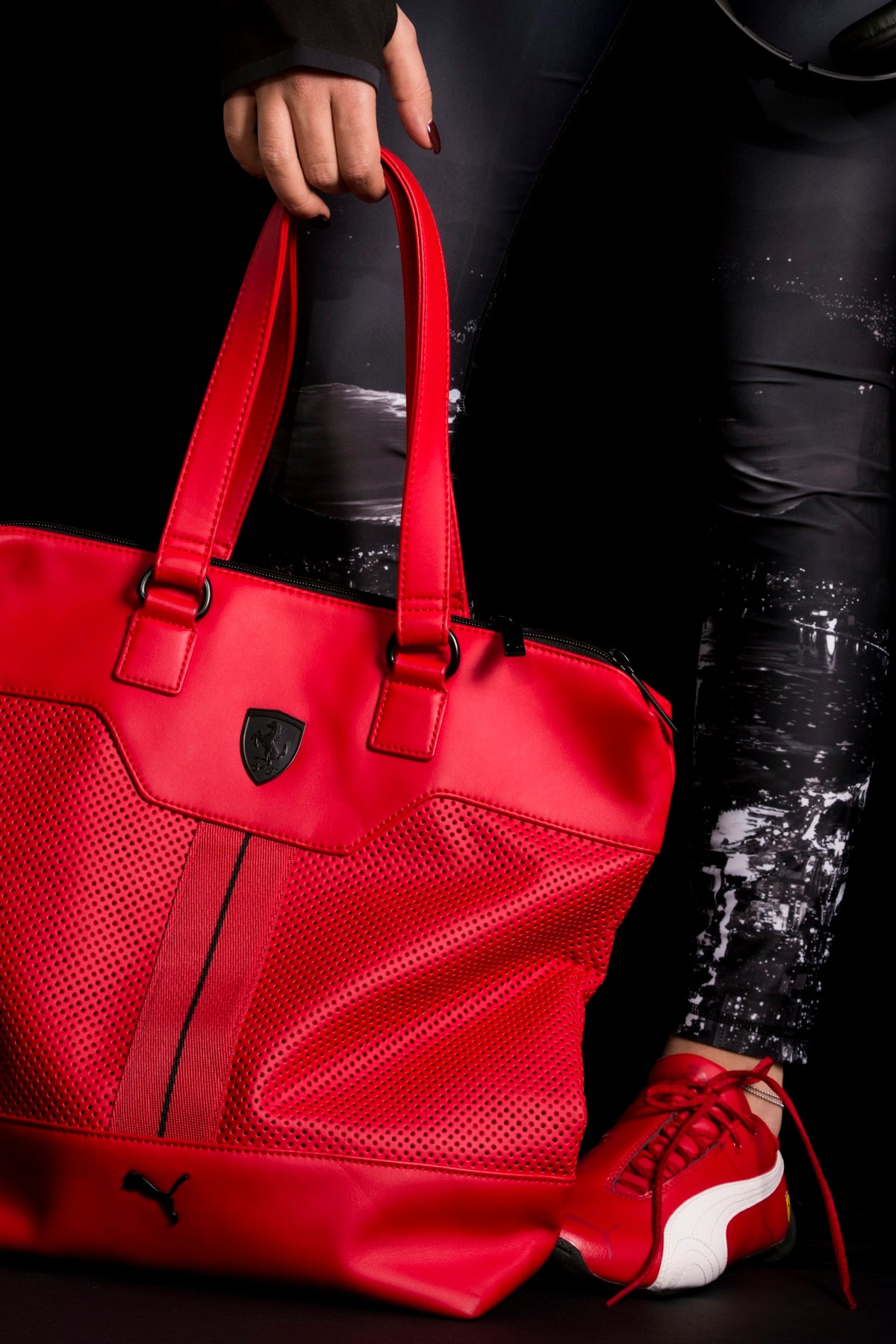 person holding red Puma leather tote bag