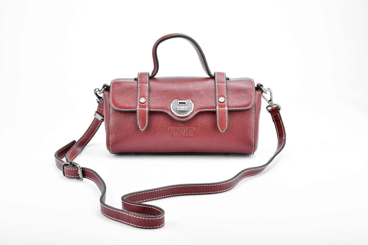 brown leather sling bag on white surface