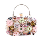 Elegant clutch with colorful 3D floral designs, pearls, and a gold handle on a beige background.