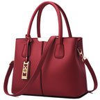 Red leather handbag with gold hardware, dual handles, and a detachable shoulder strap.