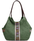 Green fabric tote bag with brown handles and colorful geometric embroidered patterns.
