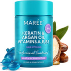 Blue jar of Marée hair serum with argan oil, keratin, and capsules, surrounded by nuts and leaves.