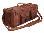 Brown leather duffel bag with two front pockets, handles, and an adjustable shoulder strap.