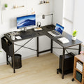 L-shaped desk with dual monitors, keyboard, lamp, plant, and books on a light wood floor.