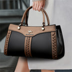 Brown and black handbag with braided details, silver logo, and round handles.