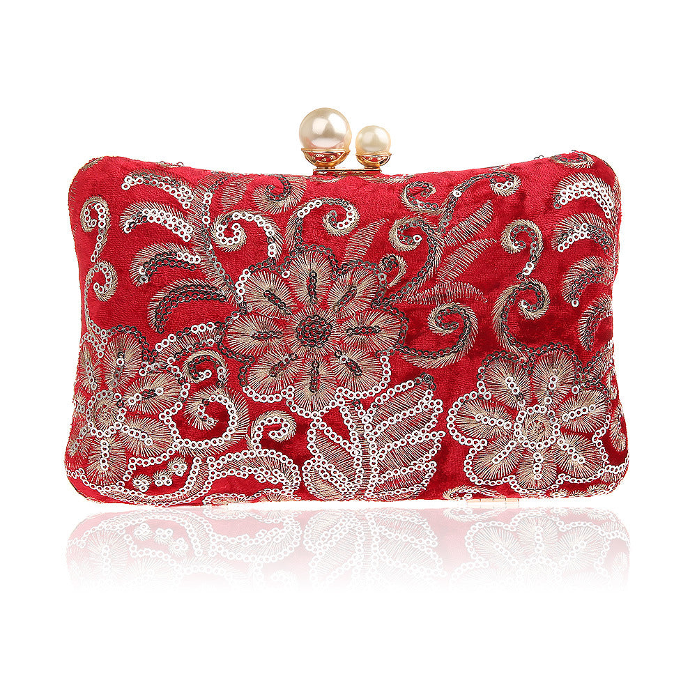 Red clutch with silver floral sequined embroidery and pearl clasp.